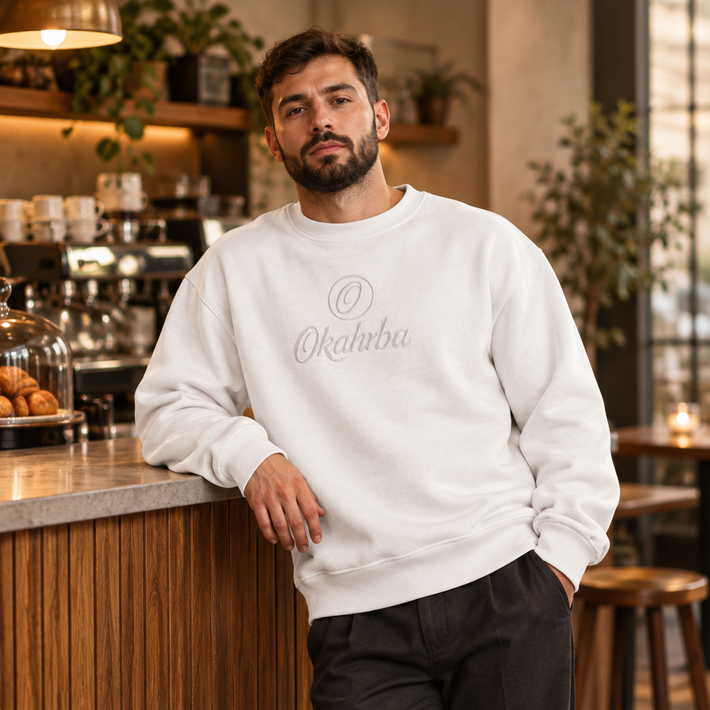 Okahrba Urban Heavyweight Sweatshirt in white, worn in a cafe