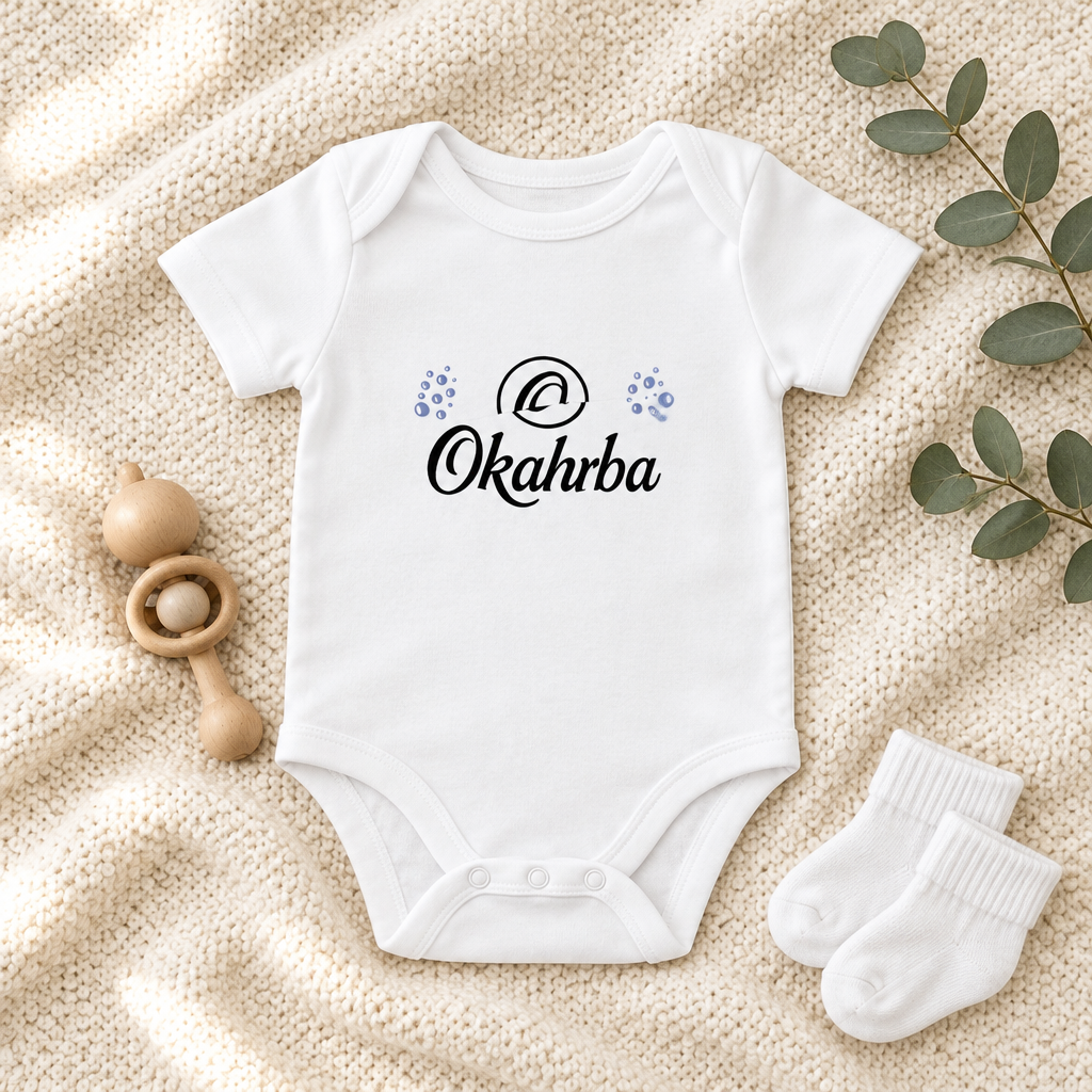 Okahrba Baby One-Piece in white, styled flat lay